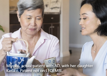 Mother pouring tea for adult daughter sitting at table