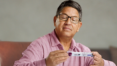 Leonard holding a LEQEMBI IQLIK® autoinjector