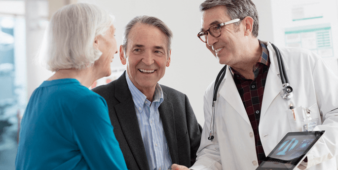 A patient and their partner talking to a healthcare provider